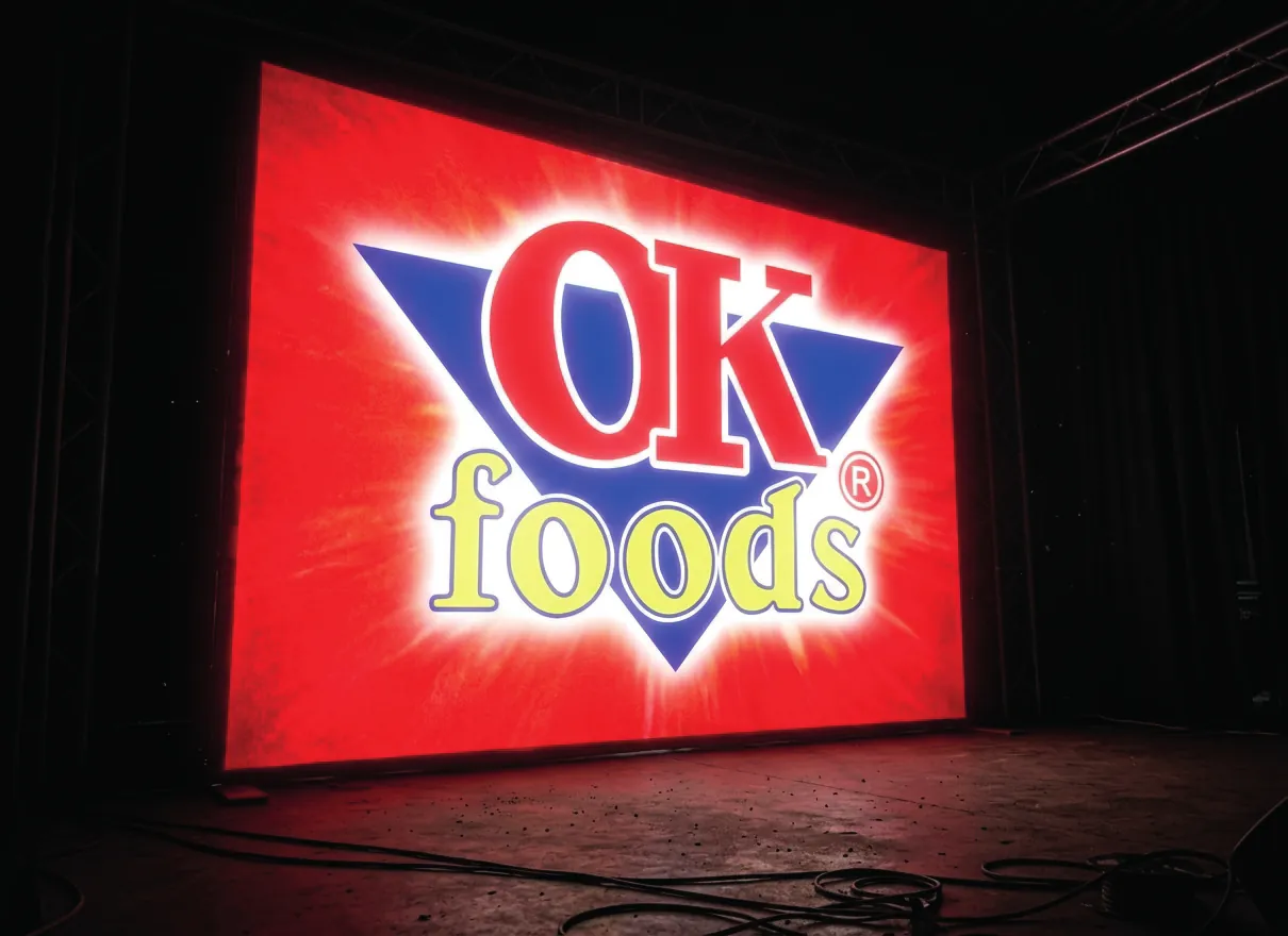 Backdrop lumineux rouge au logo OK Foods sur une scène